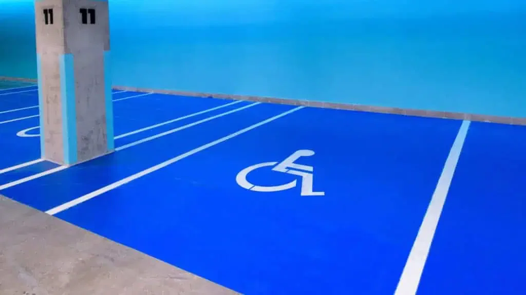 A blue and white parking lot with a wheelchair ramp.