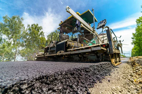 maching putting petromat on road