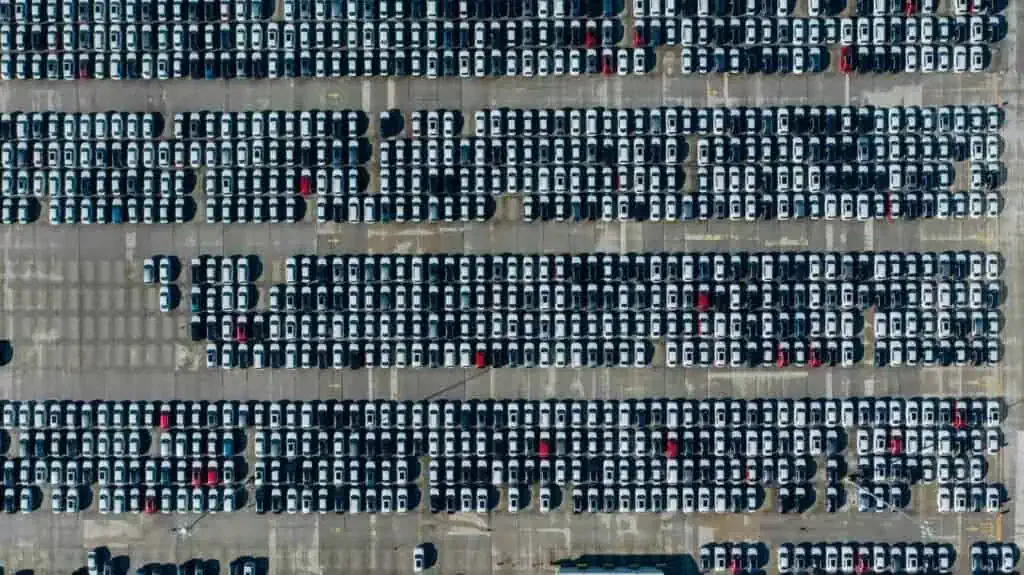 Aerial view of a large parking lot filled with rows of parked cars.