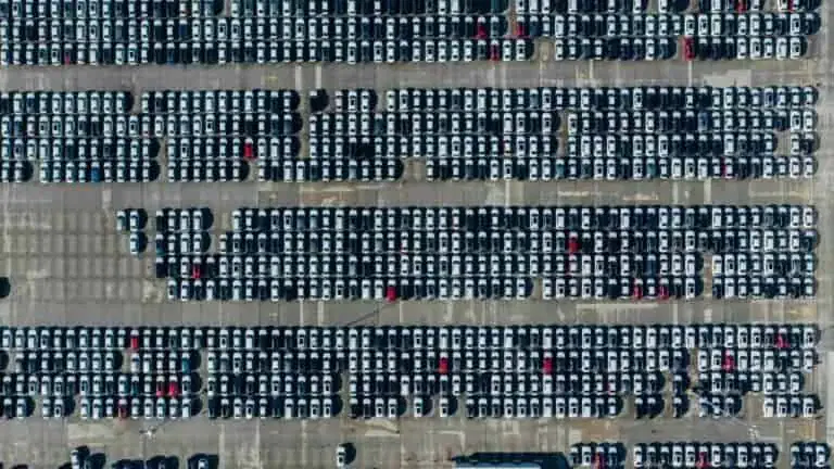 Aerial view of a large parking lot filled with rows of parked cars.