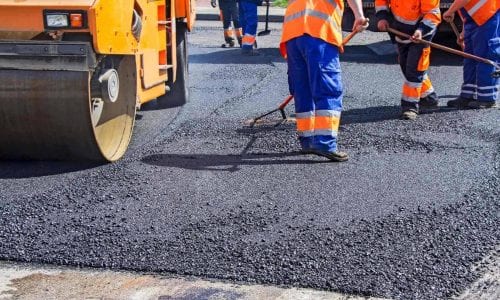 A group of workers working on a paved road.