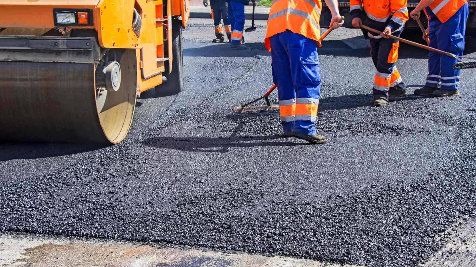 A group of workers working on a paved road.