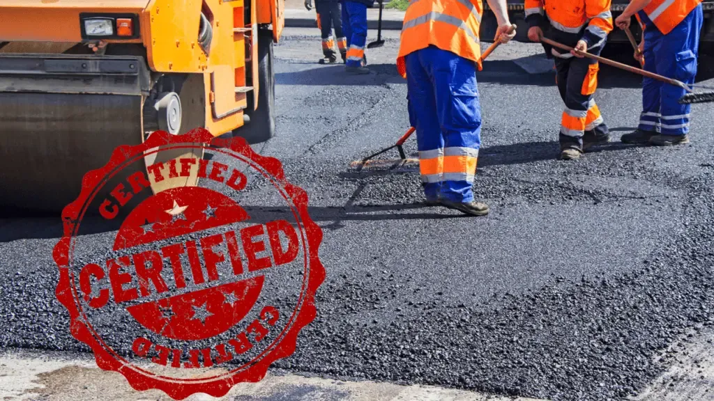 A group of workers are working on a paved road.