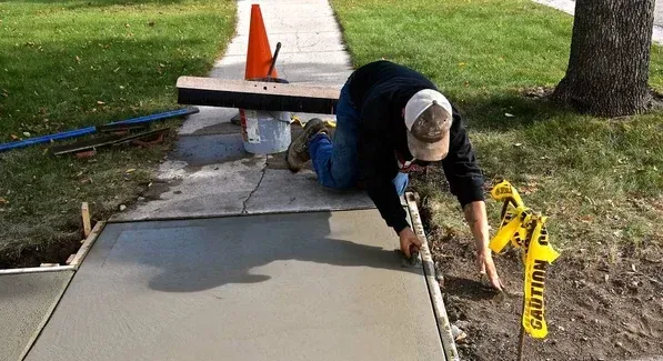 contractor repairing concrete sidewalk