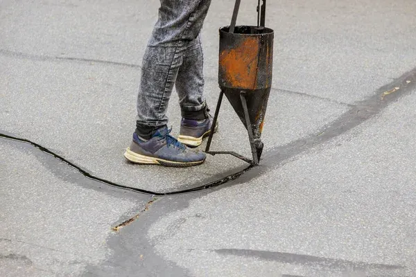 sealing cracks on asphalt with machine