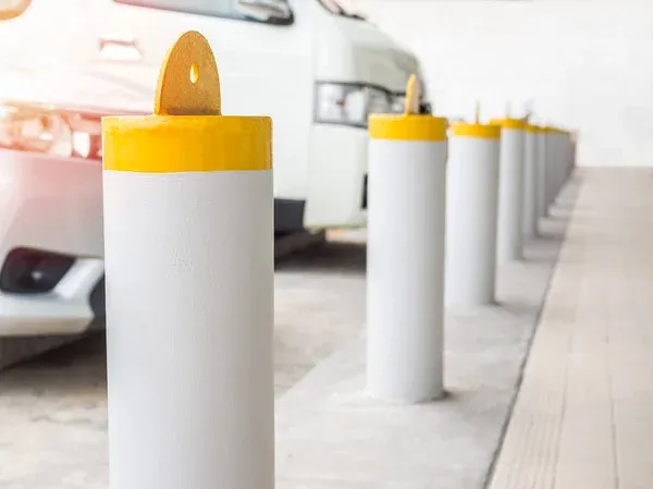 white and yellow bollards on parking lot