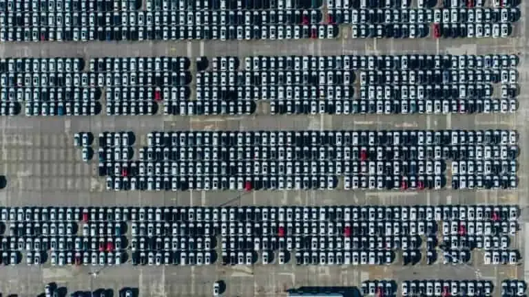 Aerial view of a large parking lot filled with rows of parked cars.
