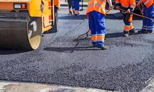 A group of workers working on a paved road.